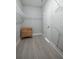 Bright walk-in closet featuring gray wood floors, a door, and white shelving for organized storage at 2400 Ezzell Ct, Sarasota, FL 34237