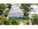 Aerial view of a modern home featuring a gray roof, driveway, pool and lush tropical landscaping at 2410 Prospect St, Sarasota, FL 34239