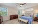 Bedroom with a queen size bed, furniture, carpet flooring, fan, and two windows at 2410 Prospect St, Sarasota, FL 34239