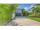 Modern home featuring a gray exterior, driveway and a well-manicured landscaped yard with lush greenery at 2410 Prospect St, Sarasota, FL 34239