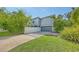 Modern home featuring a gray exterior, driveway and a well-manicured landscaped yard with lush greenery at 2410 Prospect St, Sarasota, FL 34239