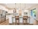 This kitchen boasts white cabinetry, stainless appliances, a center island, and modern pendant lighting at 2410 Prospect St, Sarasota, FL 34239
