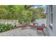 Charming patio area with comfortable wicker seating and privacy fencing surrounded by lush tropical greenery at 2410 Prospect St, Sarasota, FL 34239
