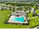 Aerial view of the neighborhood clubhouse, pool, and surrounding green spaces and residences at 2450 Dovesong Trace Dr, Ruskin, FL 33570