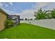 This backyard features a lush green lawn, new fence and a view of a screened in patio at 2450 Dovesong Trace Dr, Ruskin, FL 33570