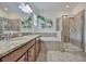 Bathroom features a walk-in shower, soaking tub, double vanity, and hanging plants at 2450 Dovesong Trace Dr, Ruskin, FL 33570