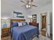 Comfortable bedroom with blue bedding, ceiling fan, and an ensuite bathroom is move-in ready at 2450 Dovesong Trace Dr, Ruskin, FL 33570