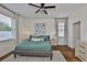 Comfortable bedroom features a ceiling fan, white walls, and two windows with blinds for natural light at 2450 Dovesong Trace Dr, Ruskin, FL 33570