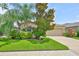 Inviting exterior featuring lush landscaping, a well-maintained lawn, and a classic tan facade at 2450 Dovesong Trace Dr, Ruskin, FL 33570