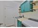 Well-organized laundry room with blue cabinets and open shelving at 2450 Dovesong Trace Dr, Ruskin, FL 33570