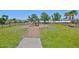 A fenced playground with swings and a slide on a well-maintained green lawn at 2450 Dovesong Trace Dr, Ruskin, FL 33570