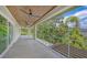 Wide covered balcony with views of lush greenery, a wood-finished ceiling, and tiled floor at 2596 Floyd St, Sarasota, FL 34239
