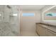 Spa bath features glass shower with niche, window, modern vanity and LED mirror at 2596 Floyd St, Sarasota, FL 34239