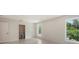 Light-filled bedroom features white tile flooring, multiple windows, and access to an en-suite bathroom at 2596 Floyd St, Sarasota, FL 34239