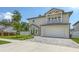 Two story home featuring a balcony, two-car garage, paved driveway, and well maintained lawn at 2596 Floyd St, Sarasota, FL 34239
