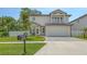Two story home featuring a balcony, two-car garage, paved driveway, and well maintained lawn at 2596 Floyd St, Sarasota, FL 34239