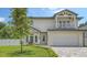 Two story home featuring a balcony, two-car garage, paved driveway, and well maintained lawn at 2596 Floyd St, Sarasota, FL 34239