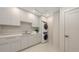 Bright laundry room features sleek cabinetry, a sink, and a stacked washer and dryer for convenience at 2596 Floyd St, Sarasota, FL 34239