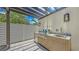 Outdoor kitchen with stainless steel grill, sink, countertop, and ample storage in a covered space at 2596 Floyd St, Sarasota, FL 34239