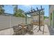 Paver patio with outdoor kitchen, wooden pergola, built-in grill, dining table, and stylish chairs at 2596 Floyd St, Sarasota, FL 34239