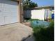 Side yard area with concrete pad, storage tank and overgrown grass at 3006 Hawthorne St, Sarasota, FL 34239