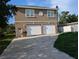 Two-story home with a double garage and a light brown facade in need of renovation at 3006 Hawthorne St, Sarasota, FL 34239