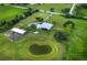 Scenic aerial view of homestead with a pond, barn, in-ground pool, and manicured grounds at 3100 Lena Ln, Sarasota, FL 34240