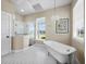 Bright bathroom with a freestanding tub, glass-enclosed shower, and classic tile flooring at 3100 Lena Ln, Sarasota, FL 34240