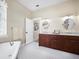 Bathroom featuring a double sink vanity, soaking tub, and stylish penny tile flooring at 3100 Lena Ln, Sarasota, FL 34240