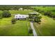 Stunning farmhouse exterior featuring a metal roof, pond, and horse barn on sprawling acreage at 3100 Lena Ln, Sarasota, FL 34240