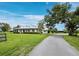 Beautiful white home with wraparound porch, manicured landscaping, and a long driveway leading up to the property at 3100 Lena Ln, Sarasota, FL 34240