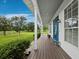 Spacious front porch with views of the manicured lawn and mature trees offers an inviting entryway to the home at 3100 Lena Ln, Sarasota, FL 34240