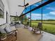 This beautiful, screened-in porch includes an outdoor kitchen, lounge seating, ceiling fans, and picturesque backyard views at 3100 Lena Ln, Sarasota, FL 34240