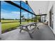 This covered patio, with its picnic table, ceiling fan, and views, offers the perfect spot for outdoor relaxation at 3100 Lena Ln, Sarasota, FL 34240