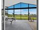 Relaxing screened patio has vaulted ceilings, open-air dining and rocking chairs overlooking grassy backyard and blue skies at 3100 Lena Ln, Sarasota, FL 34240