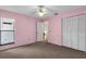 Bedroom featuring neutral carpet, a ceiling fan, a window, and a large closet with bi-fold doors at 327 40Th W Ct, Palmetto, FL 34221