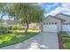 Street view of a single-story home with an attached two-car garage and well-manicured lawn at 327 40Th W Ct, Palmetto, FL 34221