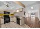 Bright kitchen features white cabinetry, black appliances, and transitions to a spacious living area with hardwood floors at 327 40Th W Ct, Palmetto, FL 34221