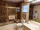 Bathroom with a gold framed shower, decorative wallpaper, and a bright vanity with a single sink at 3764 Torrey Pines Blvd, Sarasota, FL 34238