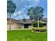 Charming single-story home with a lush lawn, stone accents, and beautiful palm trees at 3764 Torrey Pines Blvd, Sarasota, FL 34238