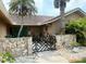 Charming home entrance with a decorative gate, stone walls, and tiled roof at 3764 Torrey Pines Blvd, Sarasota, FL 34238
