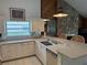 Bright kitchen featuring white cabinets, a stone accent wall, and stainless steel appliances at 3764 Torrey Pines Blvd, Sarasota, FL 34238