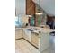 Charming kitchen with white cabinetry, a stainless steel dishwasher, and a bar-style countertop for dining at 3764 Torrey Pines Blvd, Sarasota, FL 34238