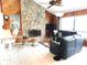 Cozy living room featuring a stone fireplace, wood-paneled walls, and comfortable leather seating at 3764 Torrey Pines Blvd, Sarasota, FL 34238