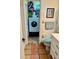 Bathroom with toilet, washer and dryer, and white cabinets for storing supplies at 3767 Pinstar Ter, North Port, FL 34287
