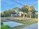 Large front yard featuring palm trees, grass, various vehicles, and a gravel spot at 3767 Pinstar Ter, North Port, FL 34287