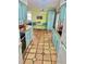 Bright kitchen with terracotta tile flooring and turquoise cabinetry with views to other areas at 3767 Pinstar Ter, North Port, FL 34287