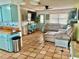 Open-concept living and kitchen area with terracotta tile flooring and a comfortable seating area at 3767 Pinstar Ter, North Port, FL 34287