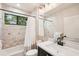 Well-lit bathroom with a combination tub and shower, vanity with sink, and decorative tile at 3906 Twin Rivers Trl, Parrish, FL 34219