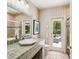 Bright bathroom featuring neutral tile, modern vessel sink, and access to a private outdoor patio at 3906 Twin Rivers Trl, Parrish, FL 34219